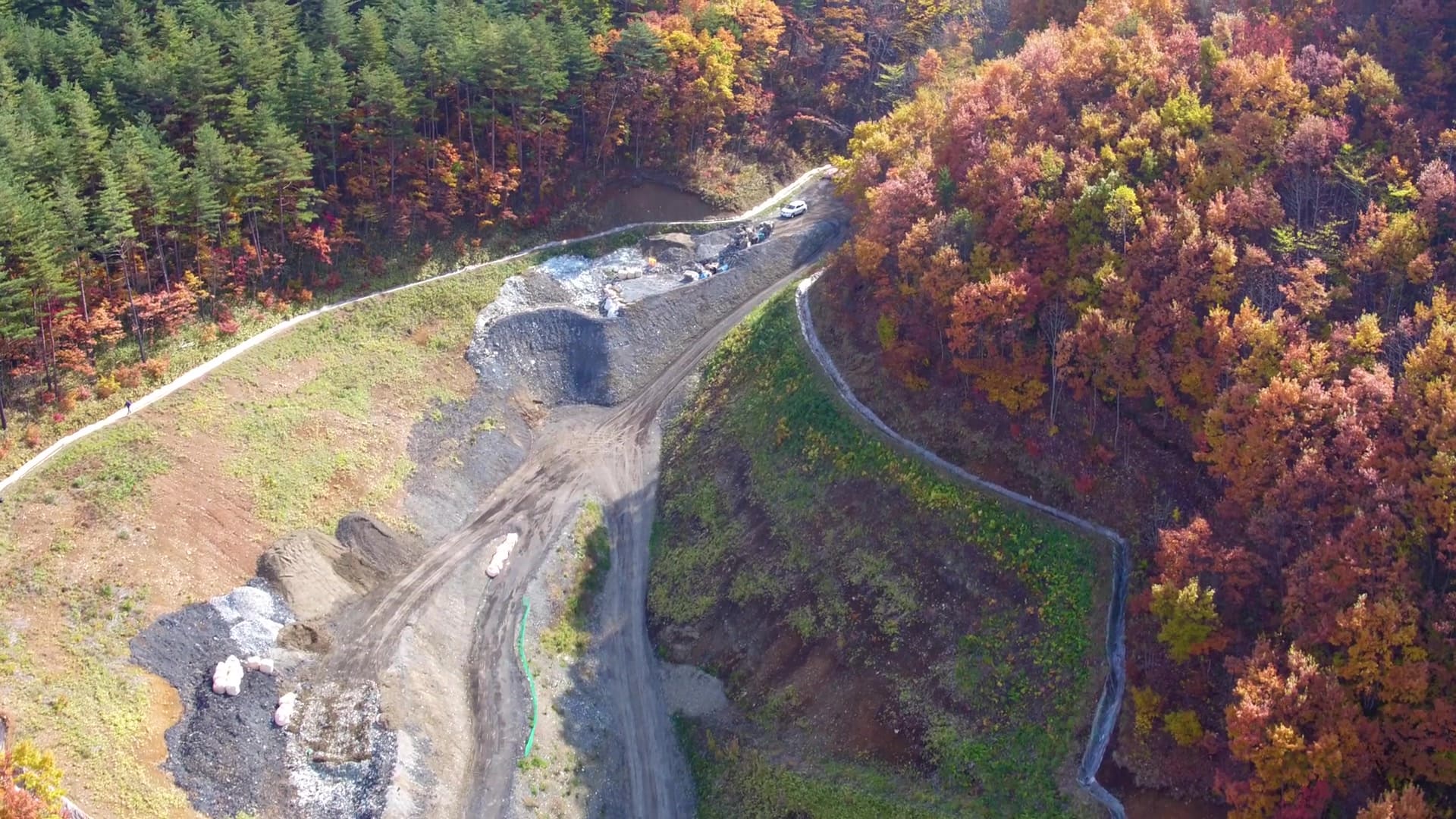 紅葉の山と施設の空撮